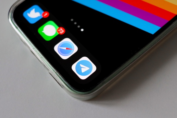 iPhone with Telegram, Safari, Twitter and iMessage apps on screen